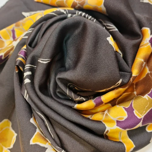 Detaliu țesătură din mătase mată cu model repetitiv de hortensii portocalii și mov pe fundal maro, ideală pentru articole vestimentare elegante de zi și ocazie